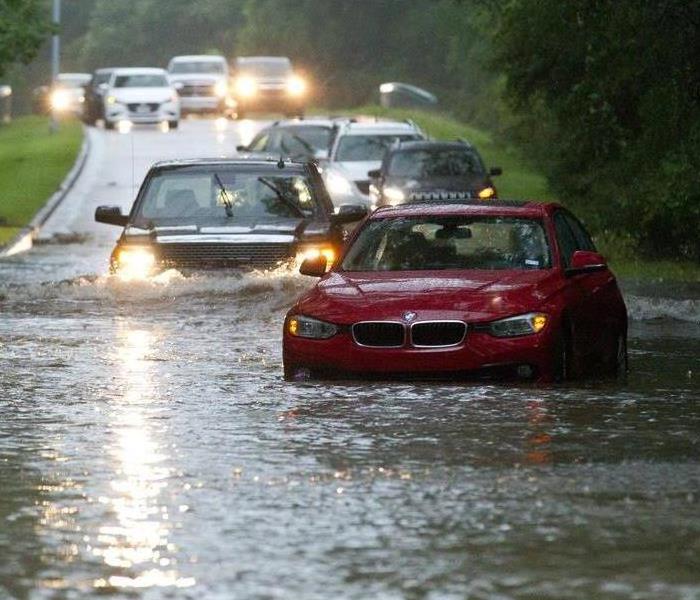 Rising flood waters traps cars in traffic during storms