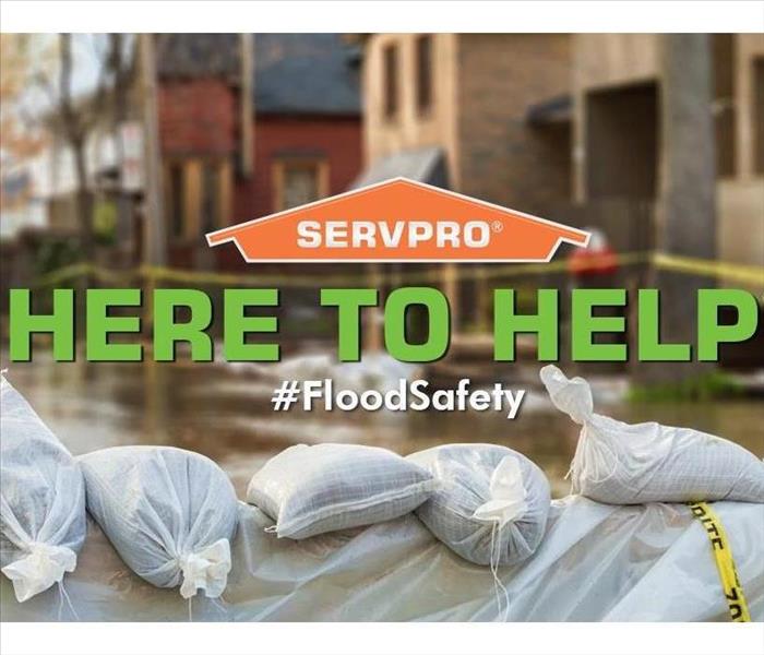 SERVPRO house logo with phrase Here to Help underneather overlaying a photo of flood covered streets with #FloodSafety phrase